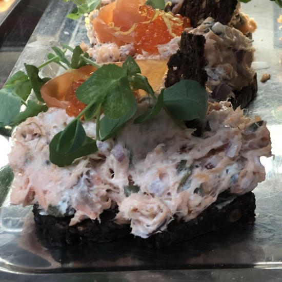 Laksesalat smørrebrød med varmrøget laks, kapers, løg, caviart og rugbrødschips Laksesalat smørrebrød med varmrøget laks, kapers, løg, caviart og rugbrødschips